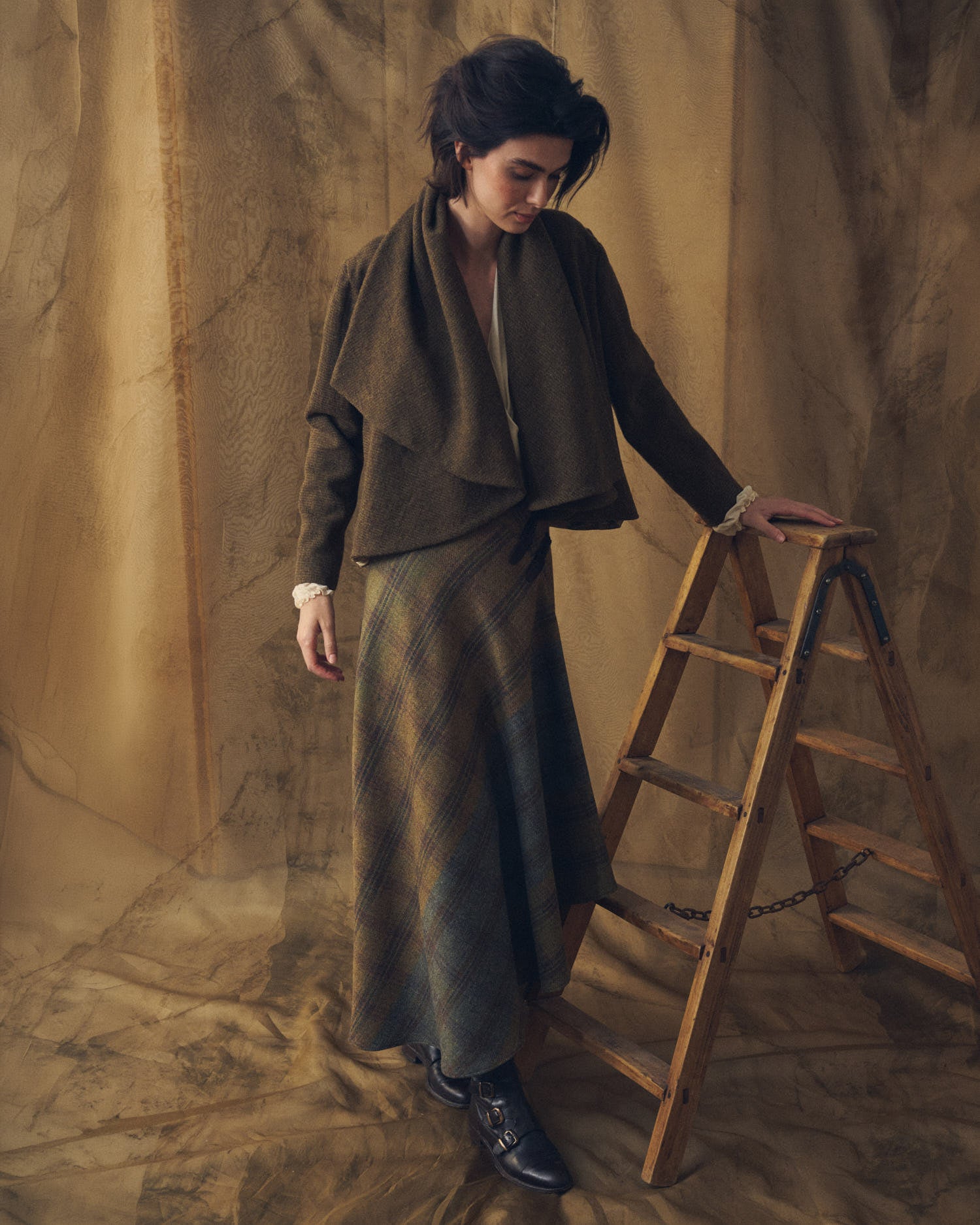 Full-length view of model wearing the brown Alina Tweed jacket styled with an A-line plaid skirt by T.ba