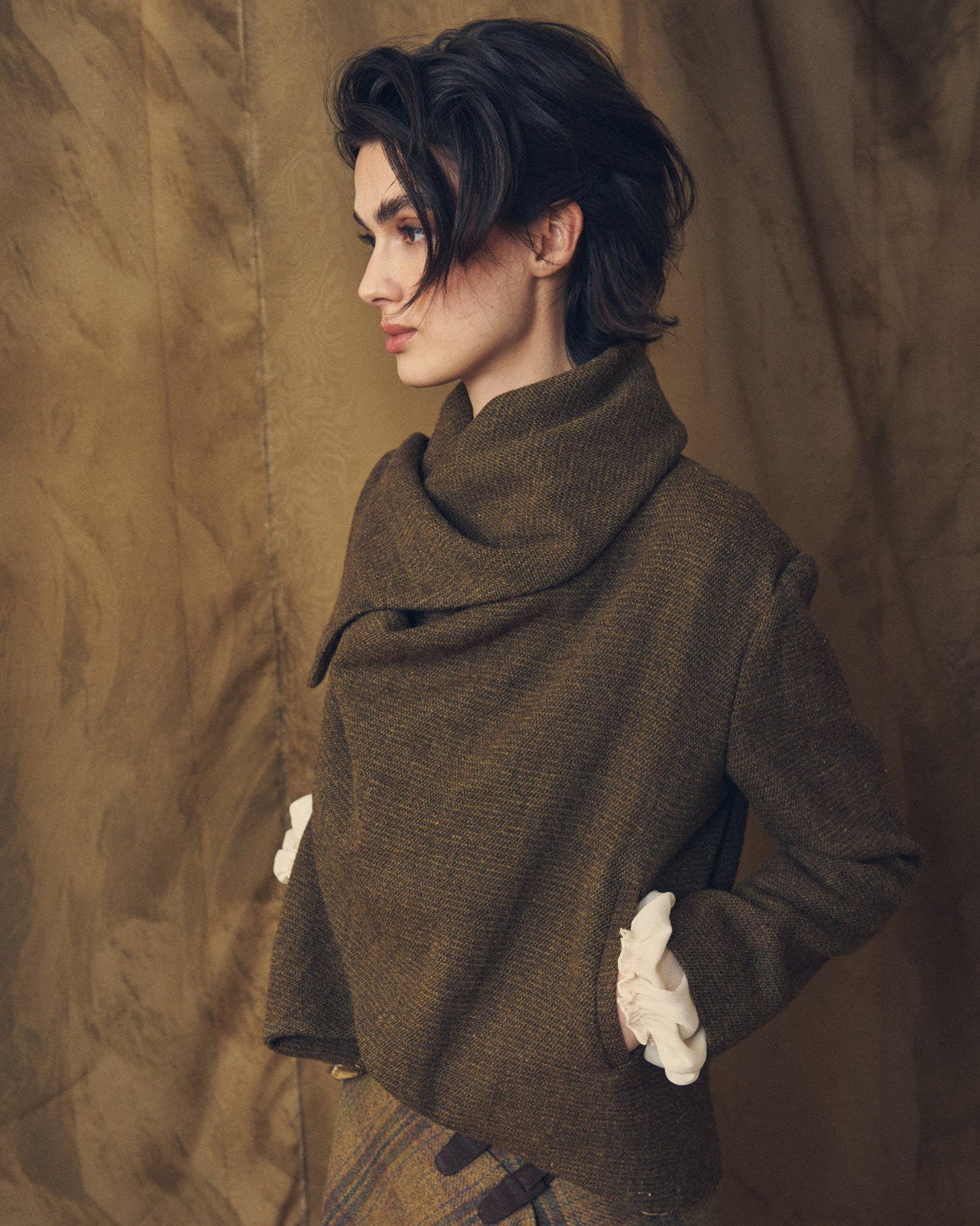 Mid-shot of model wearing the Alina Tweed short jacket styled with a high crossover collar by T.ba
