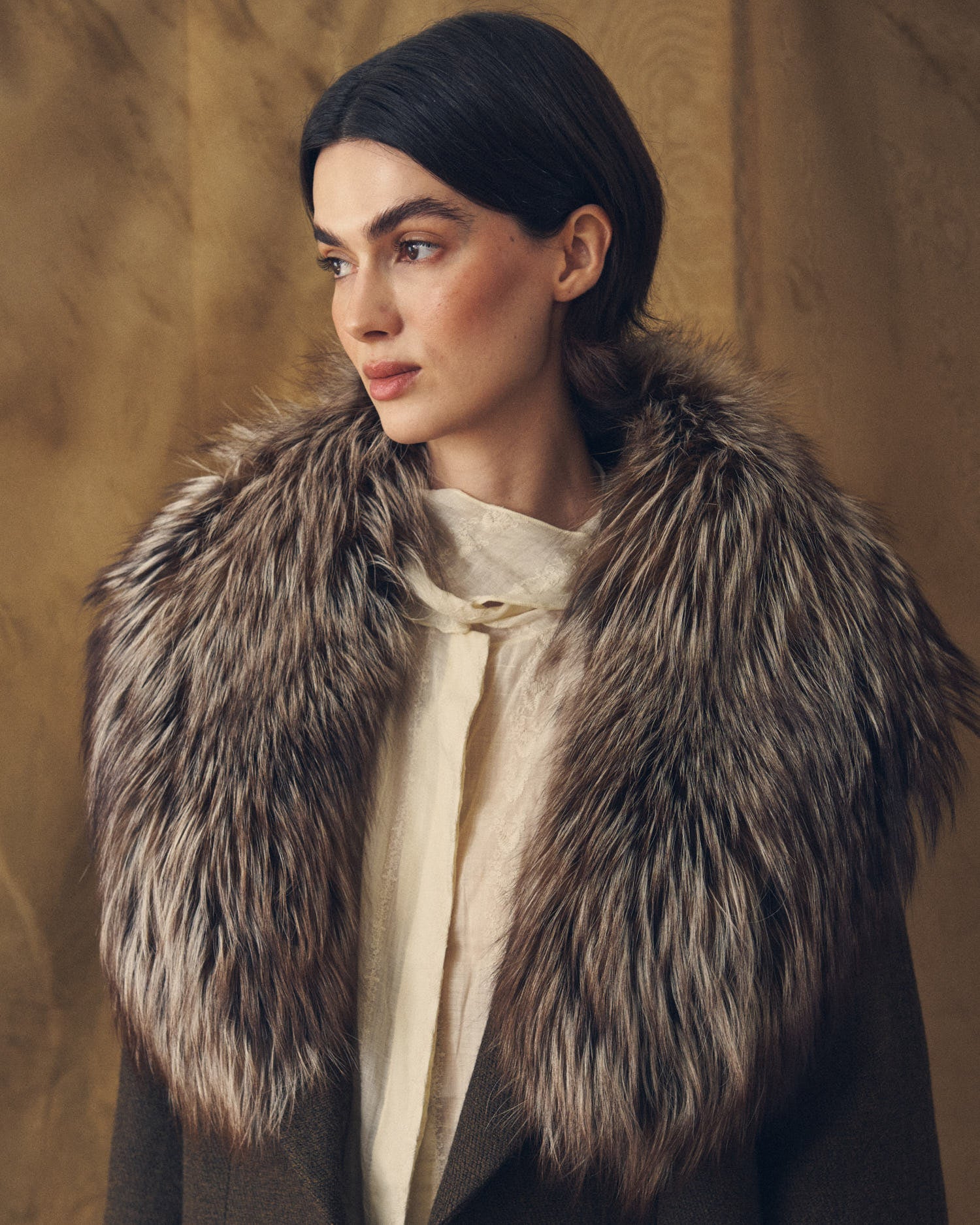 Medium portrait shot of model wearing the Baltea natural brown faux fur collar over coat by T.ba