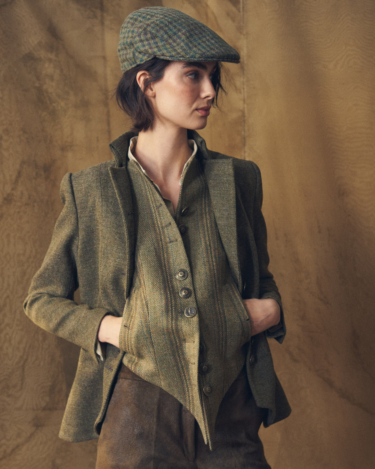 Mid-shot of model wearing the Baltea Tweed brown green jacket with matching vest and flat cap by T.ba