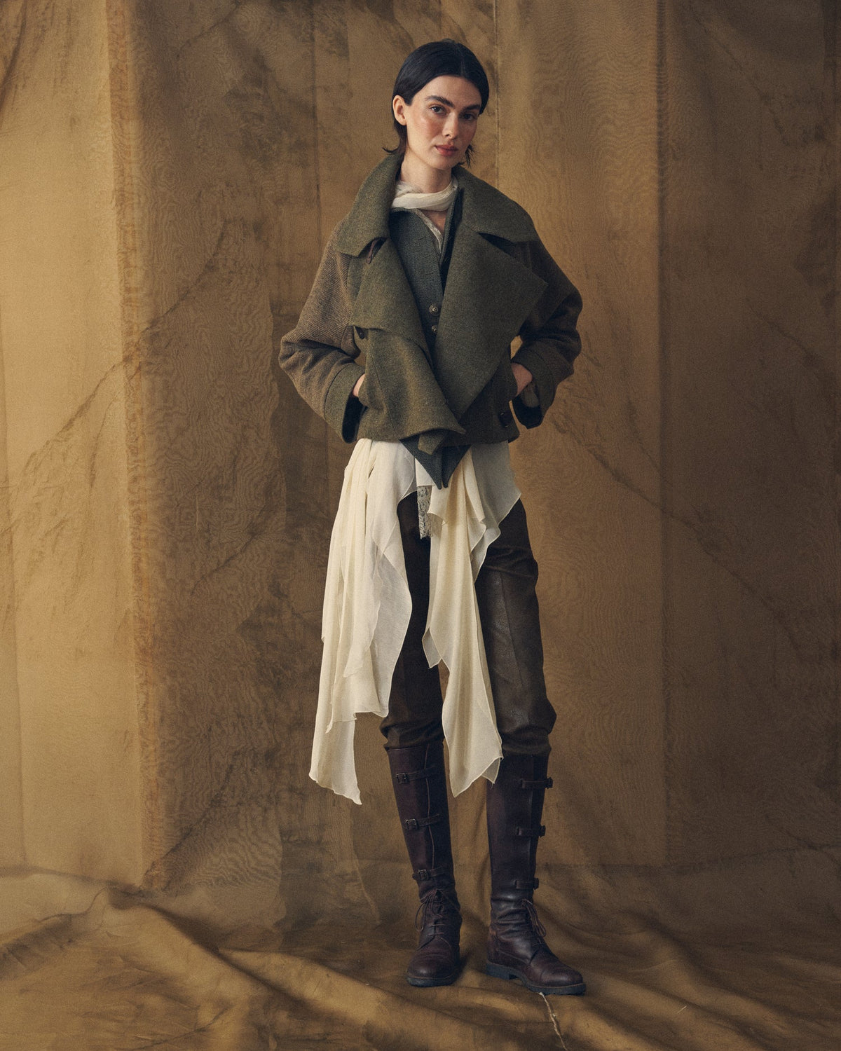 Full-length front view of the Biella bomber jacket in khaki tweed wool and knit styled with a flowing blouse and leather boots for women T.ba
