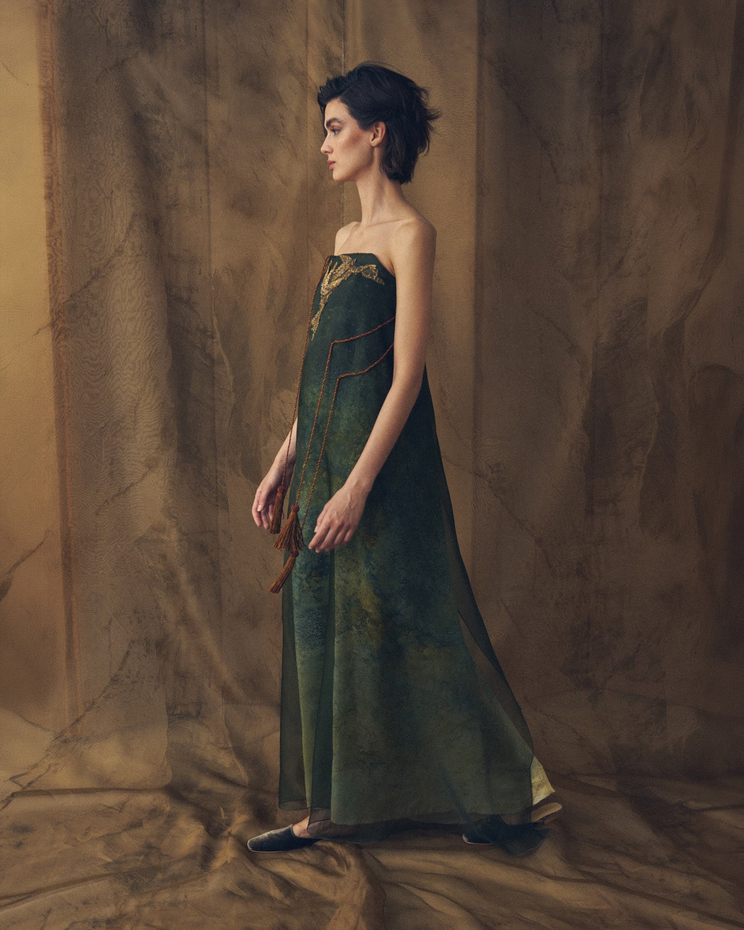 Side profile full-length view of Birdie strapless fluid organza long dress in bayou green for women by T.ba