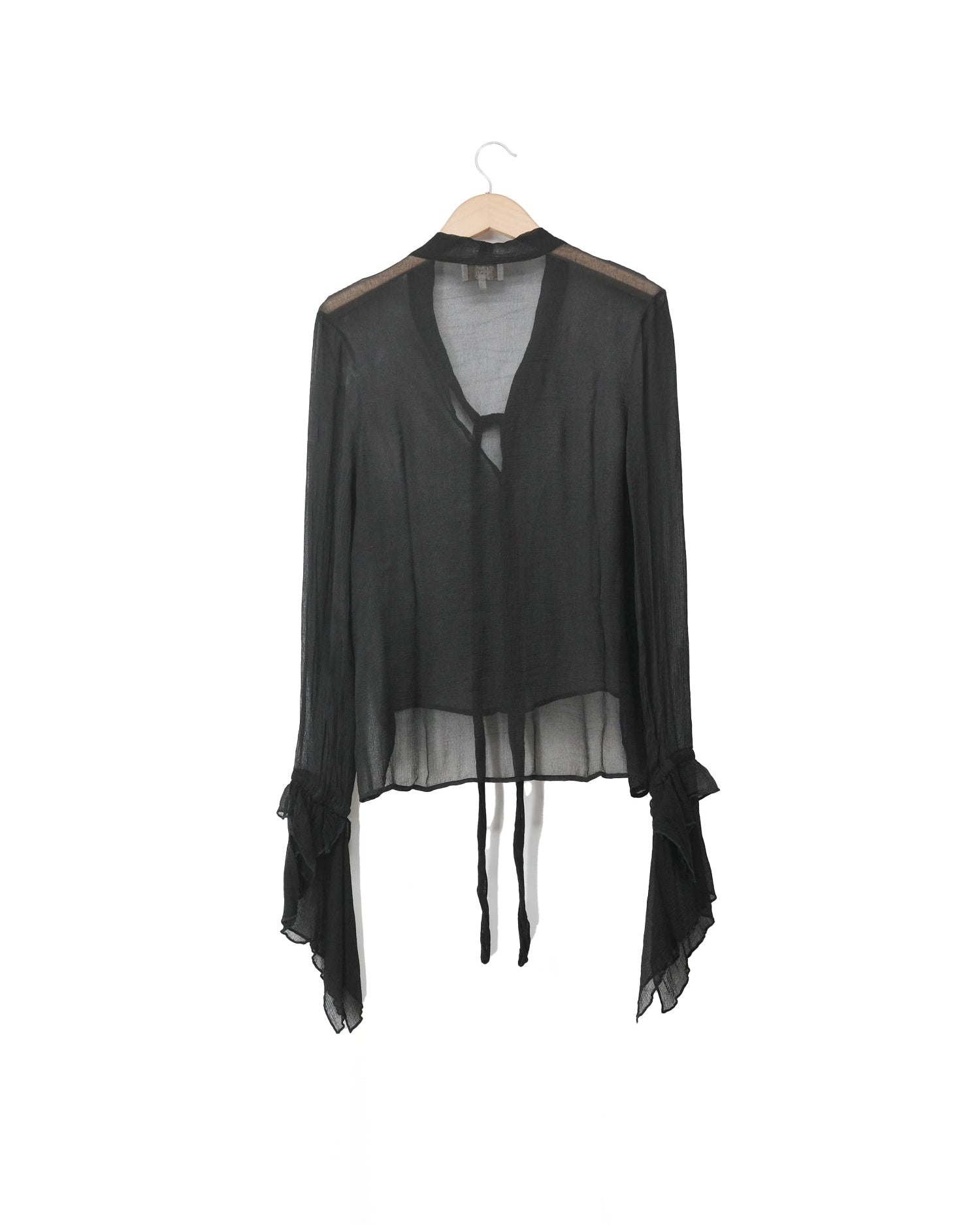 Back view of women's sheer black chiffon Mia blouse with front tie closure, V-neckline, and flared ruffled cuffs by T.ba