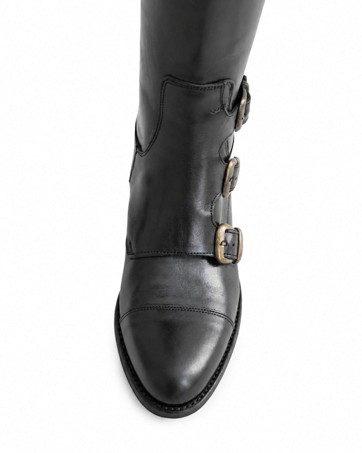 Detailed close-up view of triple antique brass buckles and stitched toe cap on black leather boots for women T.ba