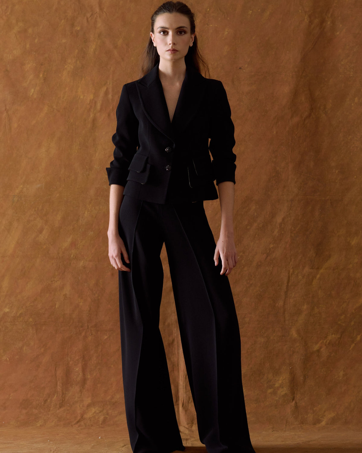 Full front view of model showcasing the complete tailored suit featuring the black Crepe Maxi Pants with wide leg fit for women by T.ba