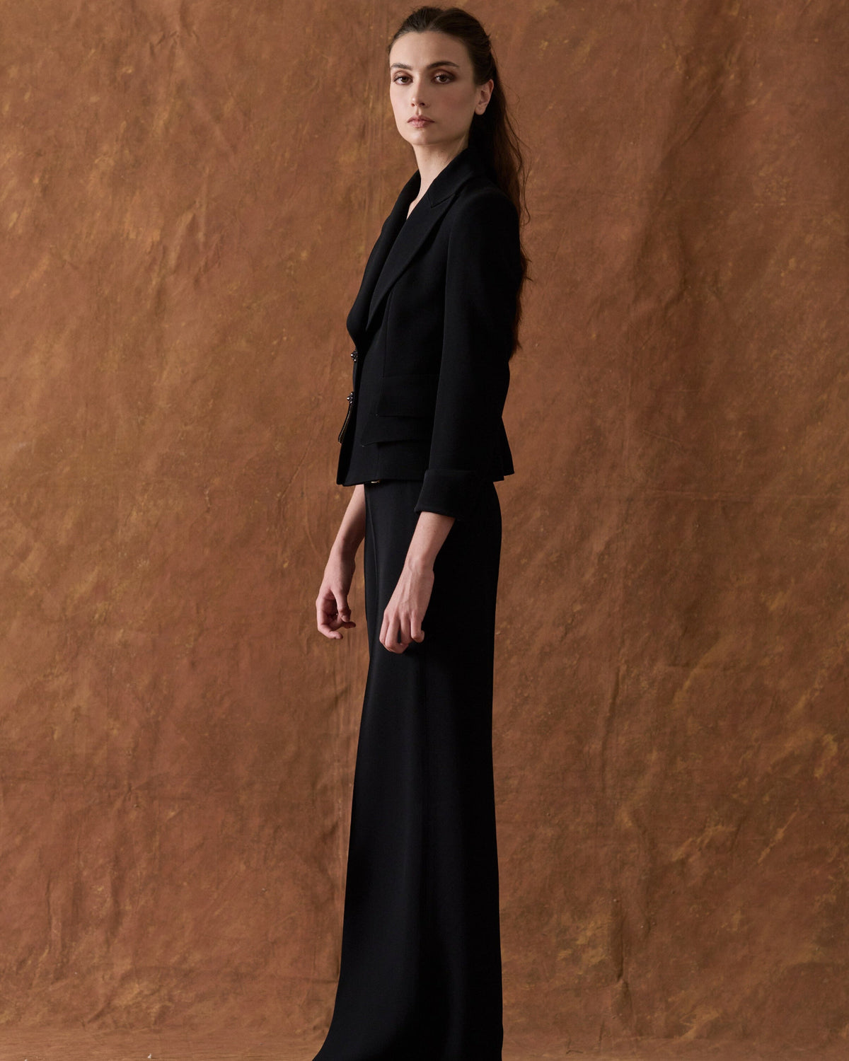 Profile side view of model wearing the fluid crepe Crepe Maxi Pants in classic black with a straight wide leg silhouette for women by T.ba