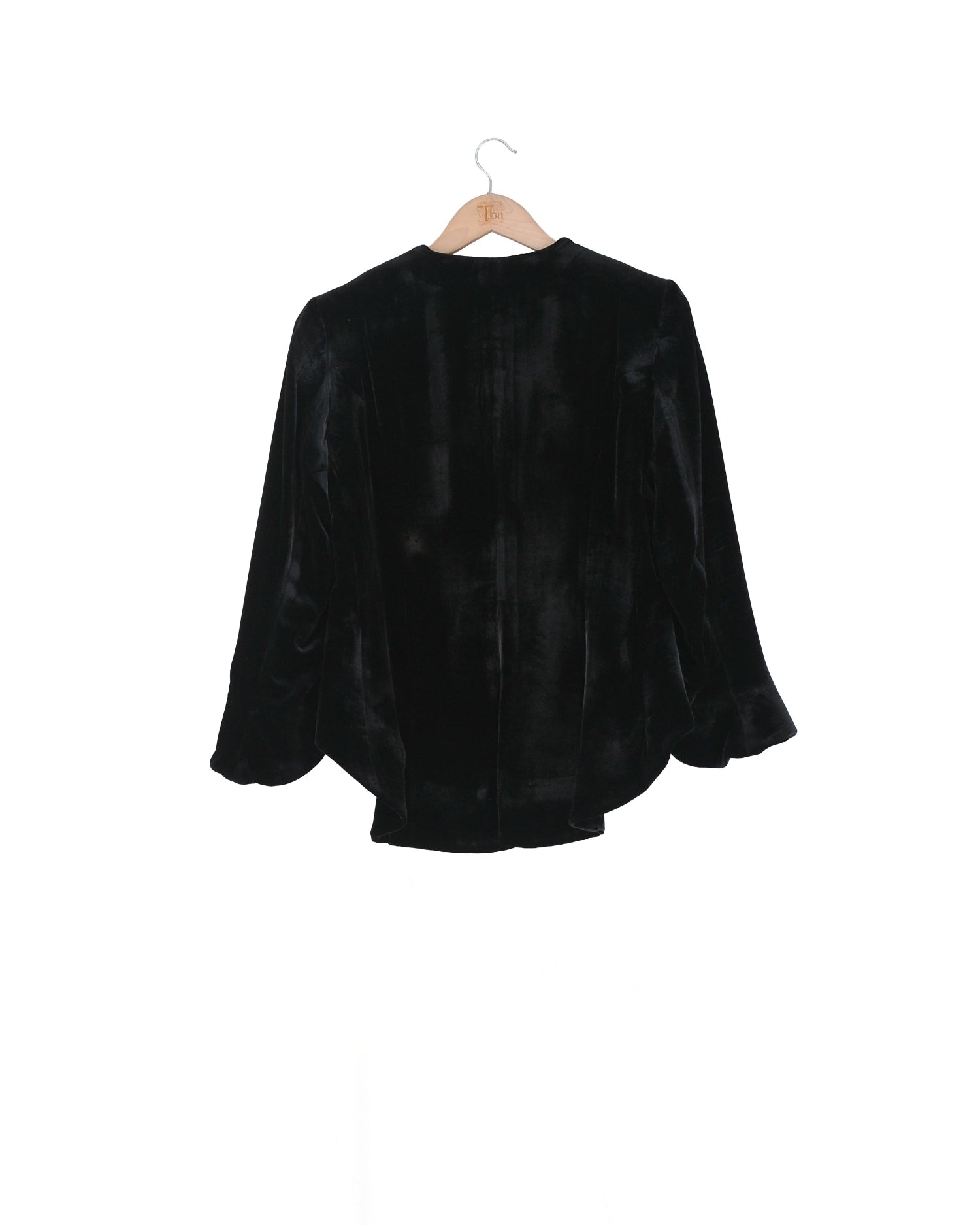 Back studio view on hanger of the Daria short silk velvet jacket in classic black by T.ba