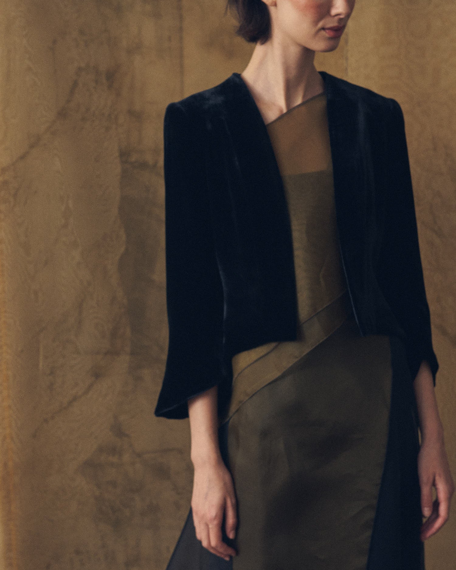 Close-up shot of model wearing the open-front Daria jacket in black silk velvet by T.ba