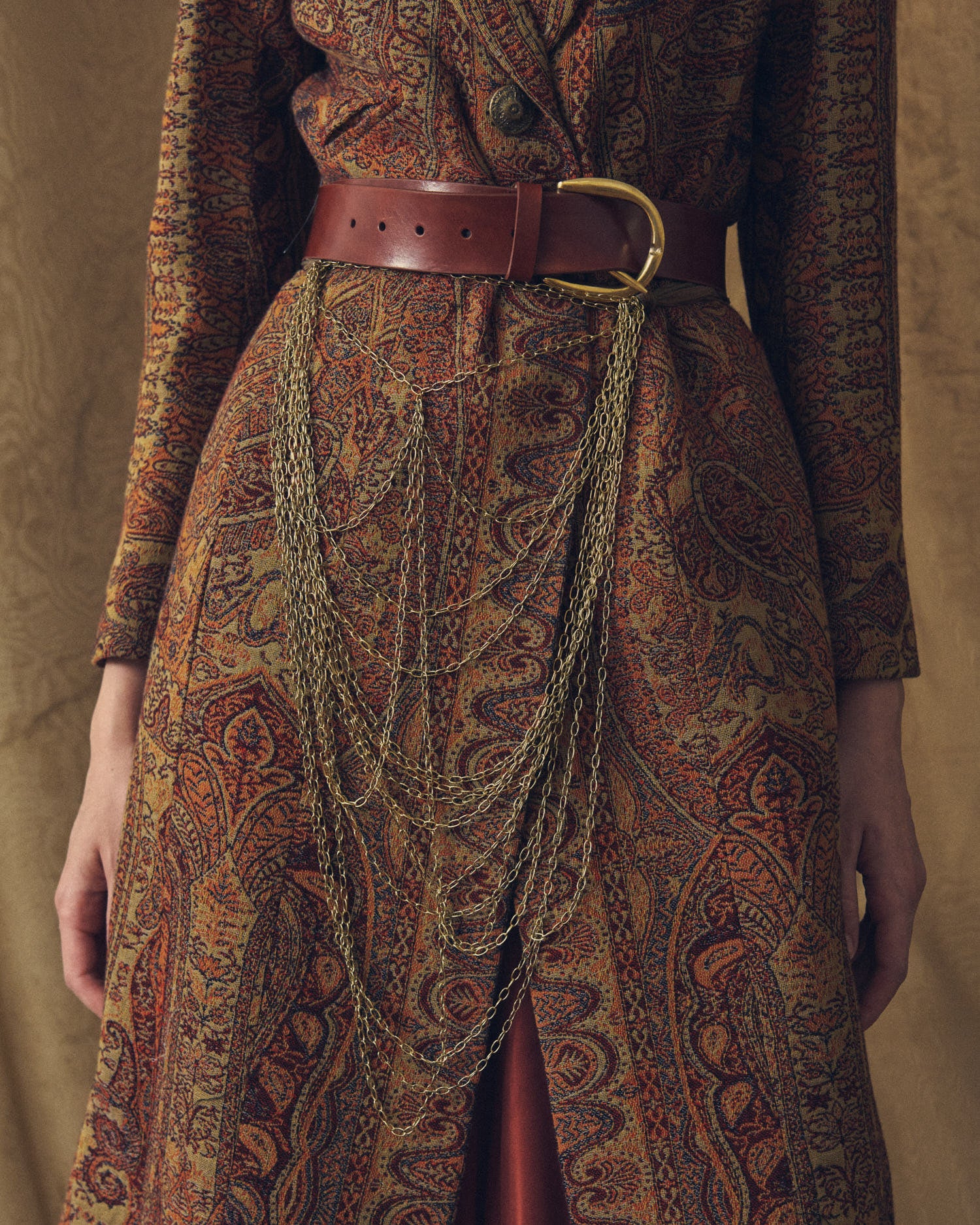 Close-up detail of the Duke Belt wide khaki leather belt with metal buckle and cascading chain accessory for women by T.ba