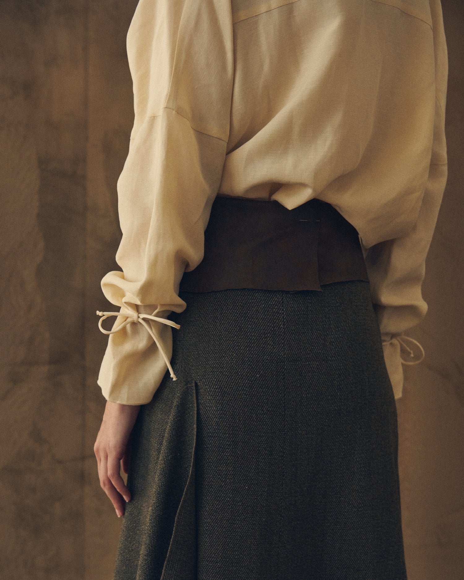 Close-up back view highlighting the cuff tie detail and fluid drape of the natural cream Eloise Cupro Blouse for women T.ba