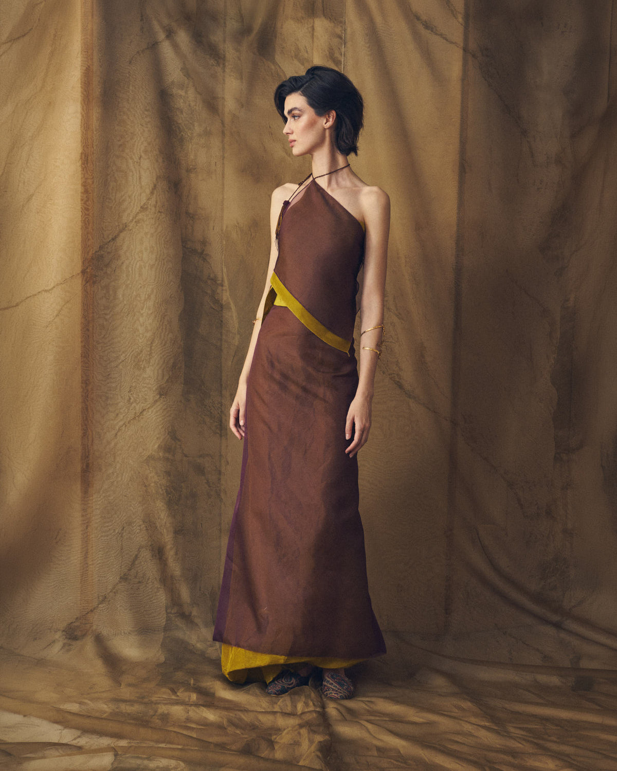 Three-quarter front studio view of the Fiore aubergine silk organza top featuring a contrast olive green waist band by T.ba