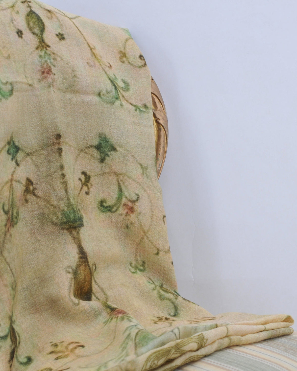 Fiore shawl draped over vintage chair showing green floral print on cream wool fabric for women T.ba