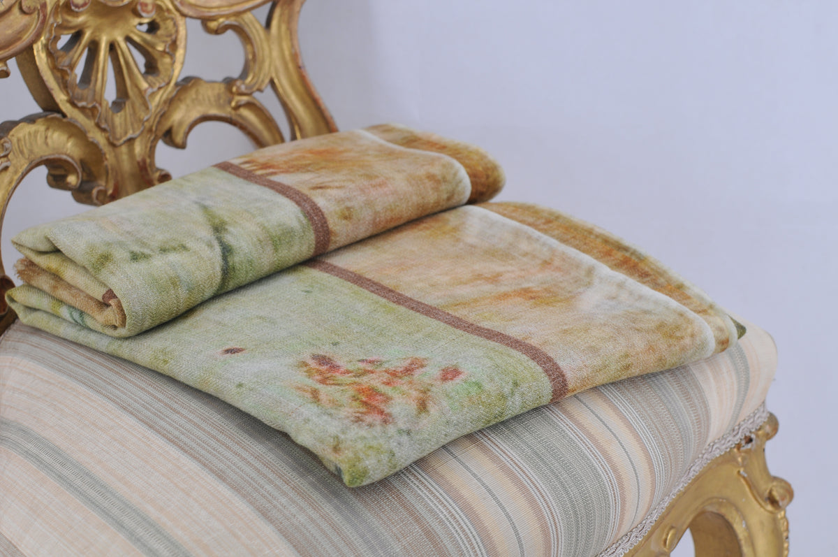 Folded Greta shawl in soft green and earth tones landscape print on classic chair for women T.ba