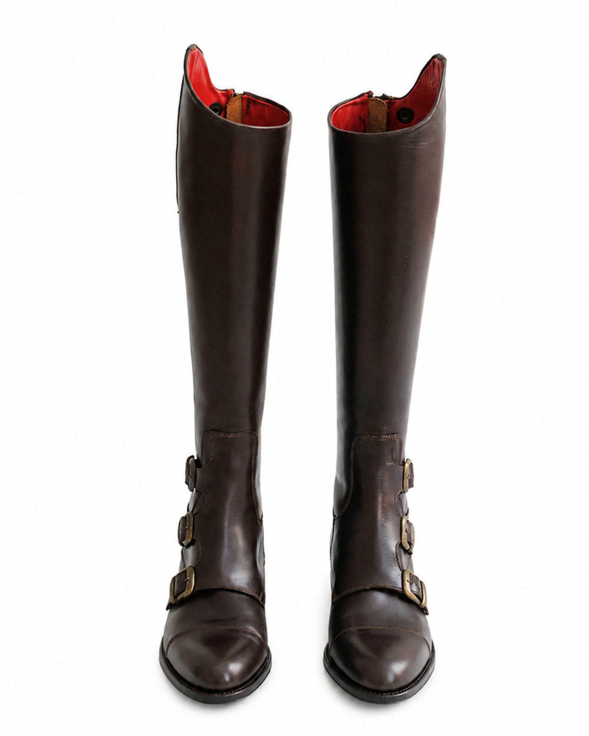 Pair shot front view of women's dark chocolate leather riding boots with brass buckles and red lining T.ba
