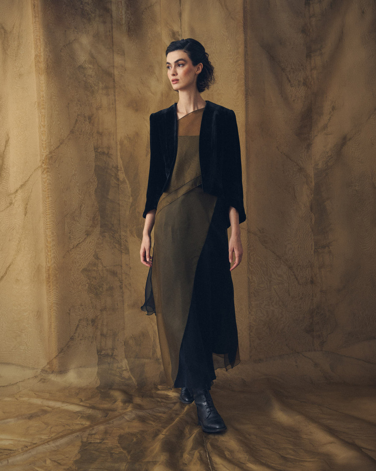 Full-length portrait of model wearing black leather straps riding boots with silk dress and blazer T.ba