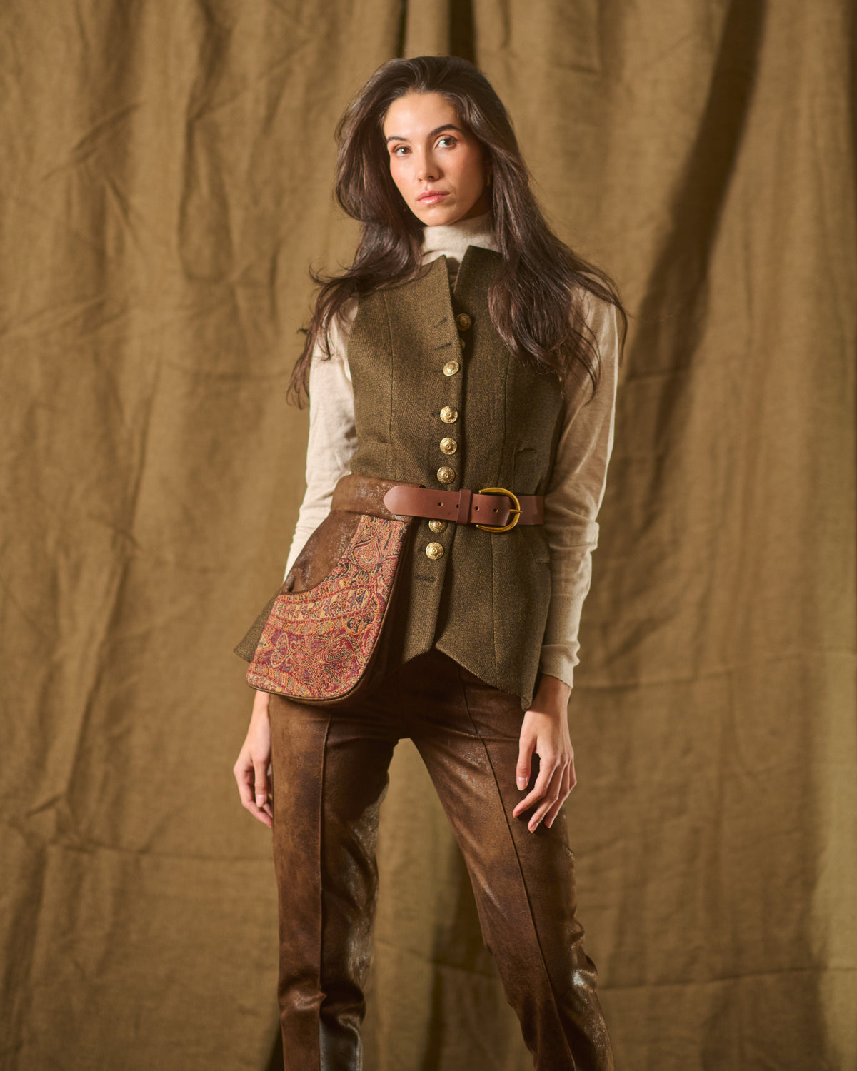 Model wearing brown leather Duke belt pouch with tapestry panel paired with vest and trousers for women T.ba