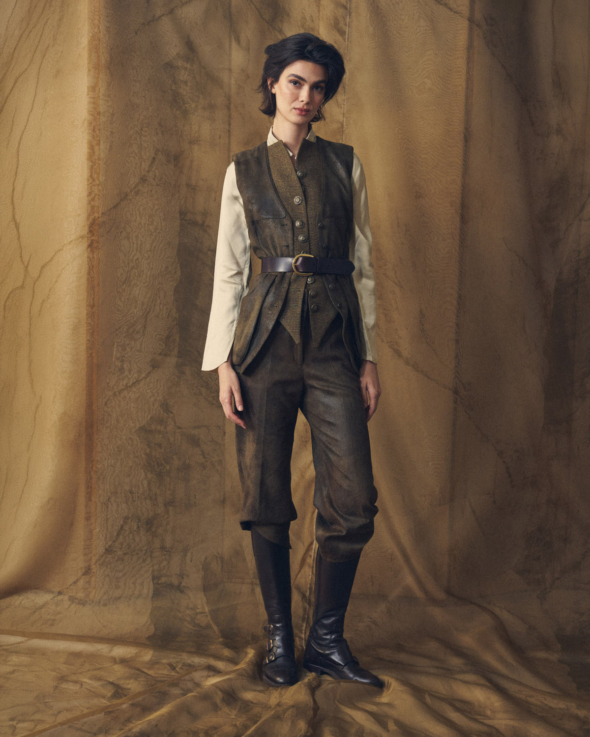 Model wearing the Gnu Shooting Vest in khaki over a cream shirt styled with a leather belt by T.ba