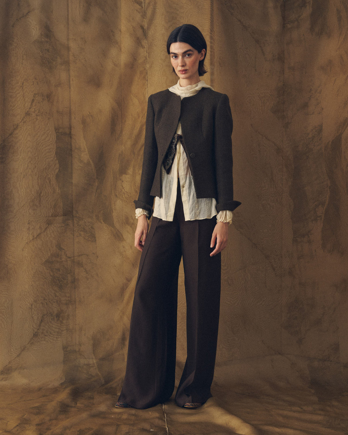 Full length front view of model wearing the Jerez Greta cropped jacket in dark brown wool with wide-leg trousers by T.ba