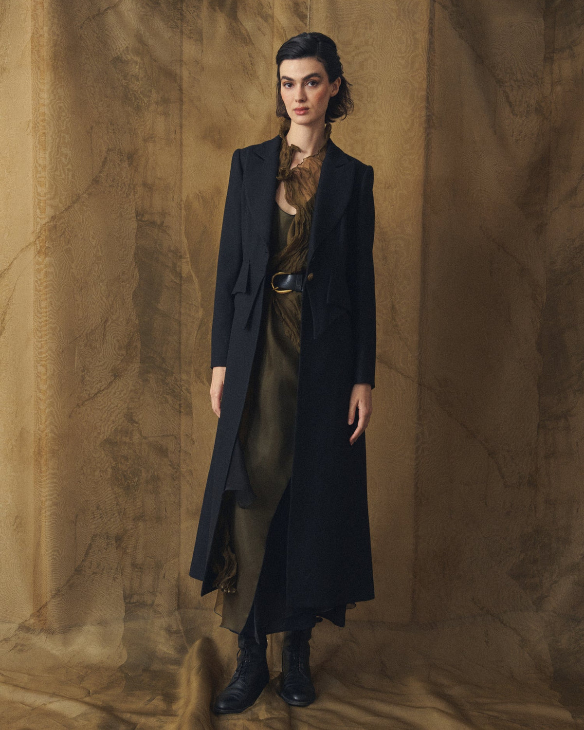 Full length front view of model wearing the long Jerez Verdi Coat in black wool with tailored lapels for women by T.ba