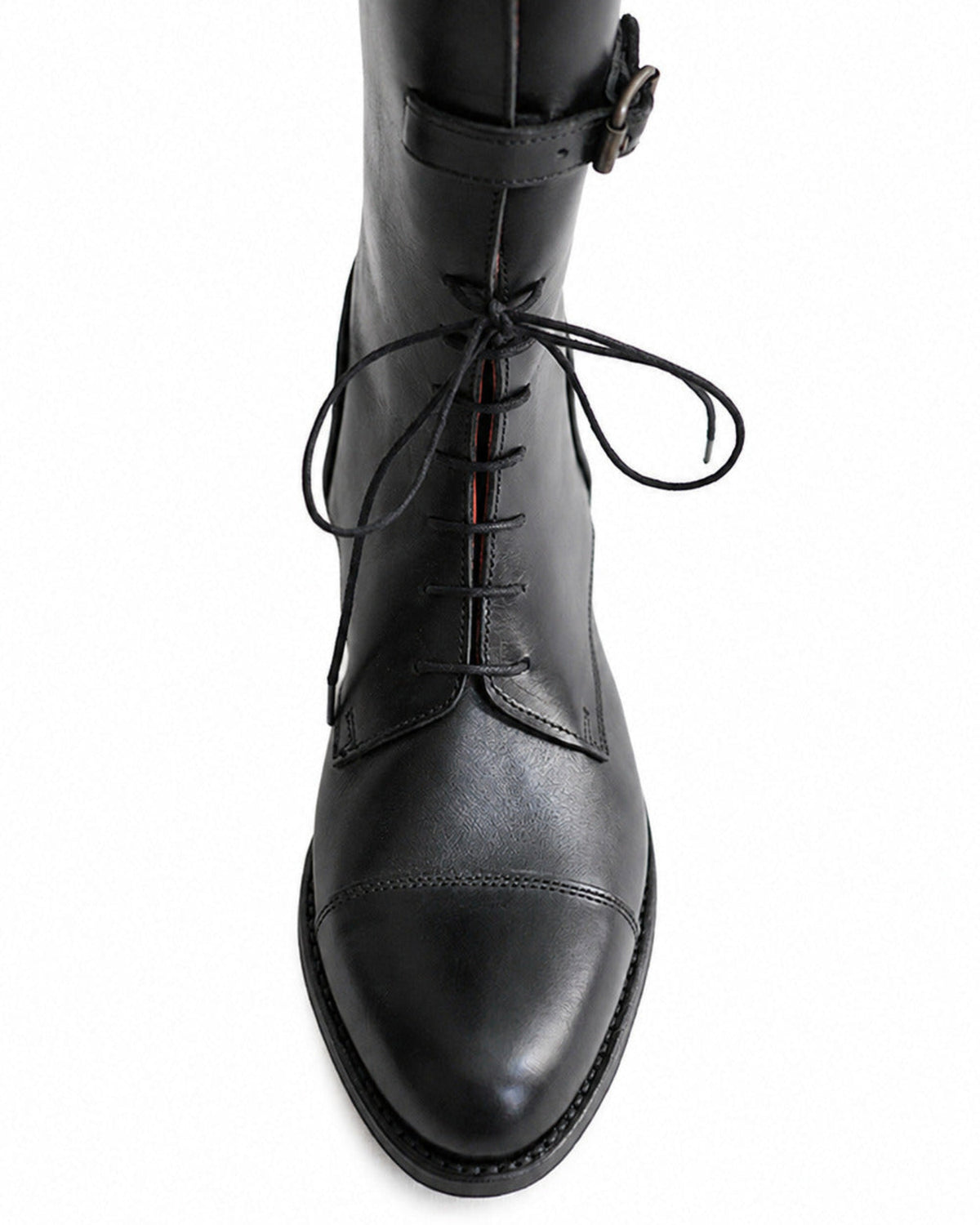 Close-up view of front laces and stitched toe cap on black leather straps knee-high boot T.ba