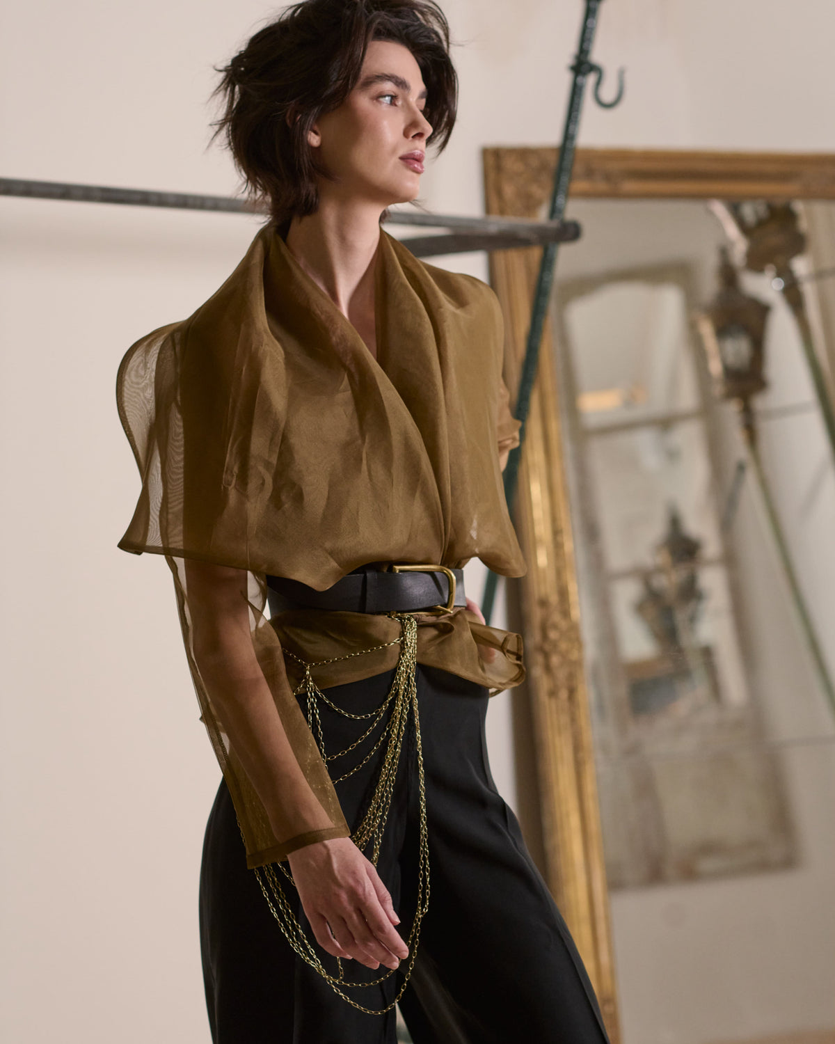 Medium close-up view of model wearing translucent Organza Alina jacket in toffee styled with leather belt for women T.ba