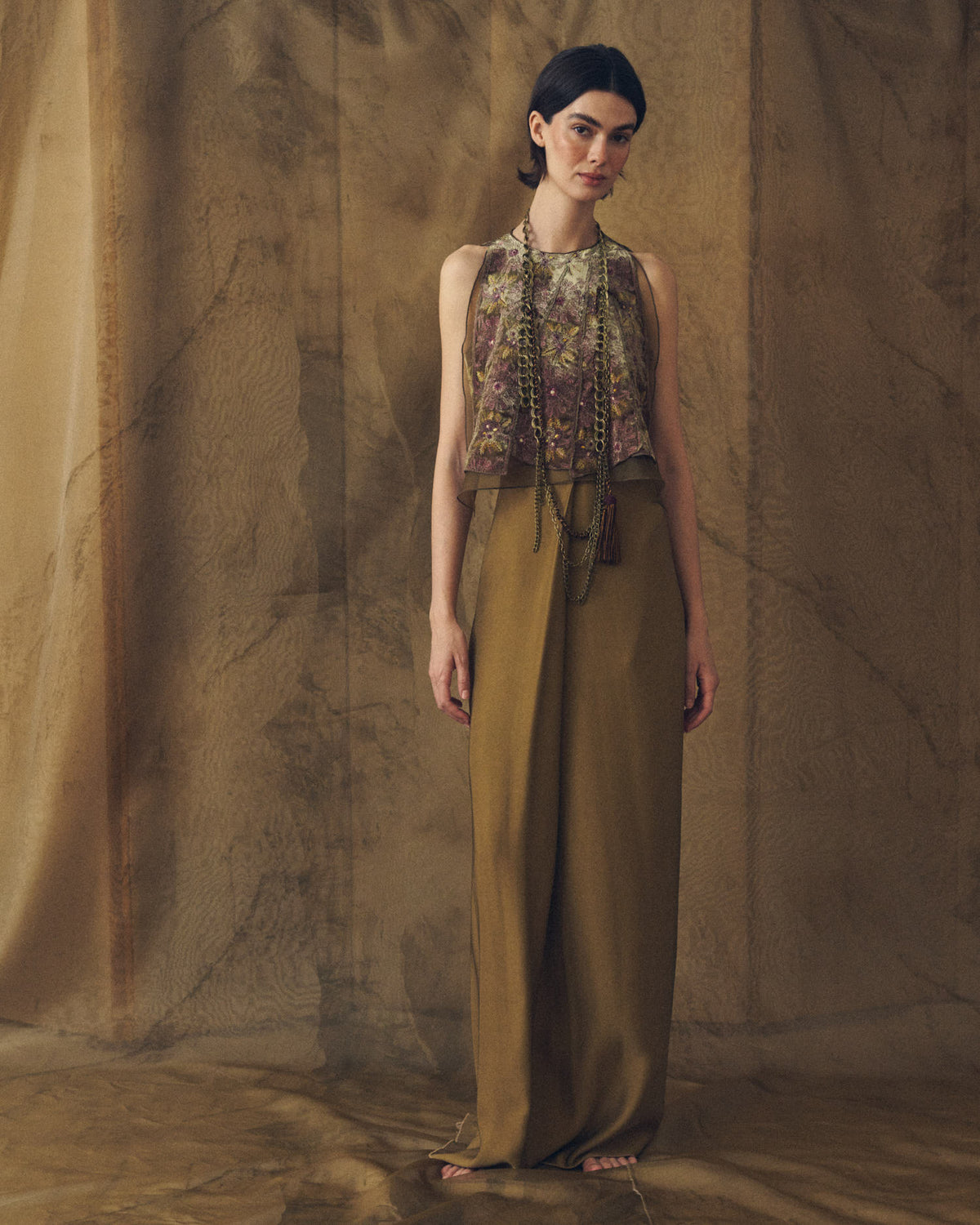 Full-length front studio view of model wearing the Noor long sharkskin skirt in khaki paired with an embroidered top by T.ba