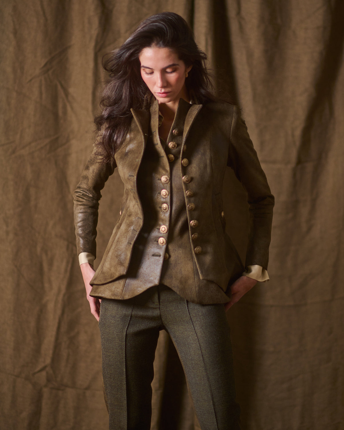 Three-quarter view of model posing in unbuttoned khaki leather Gnu Baltea jacket with double-breasted detail T.ba