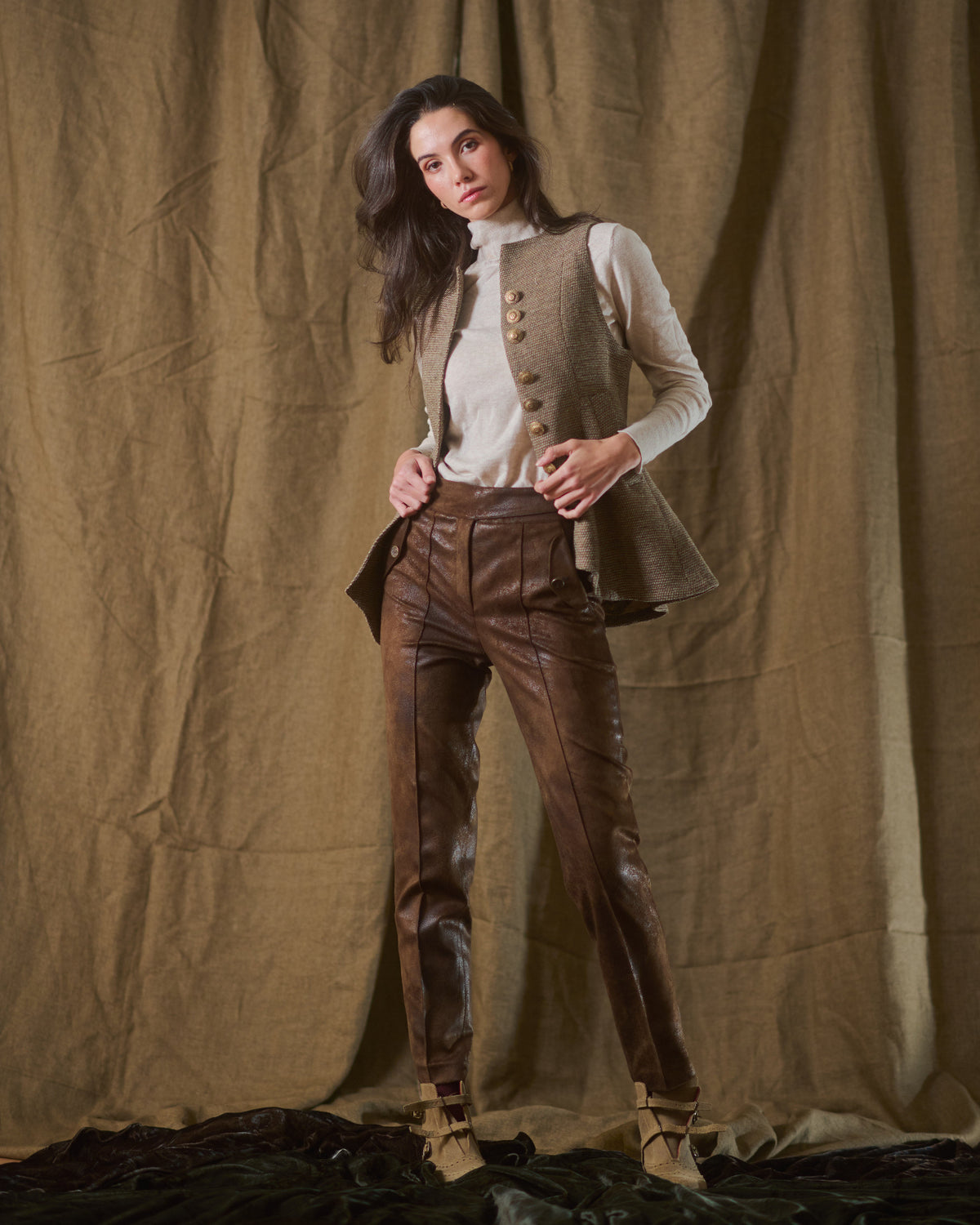 Model wearing unbuttoned taupe tweed knit Baltea vest layered over turtleneck sweater T.ba