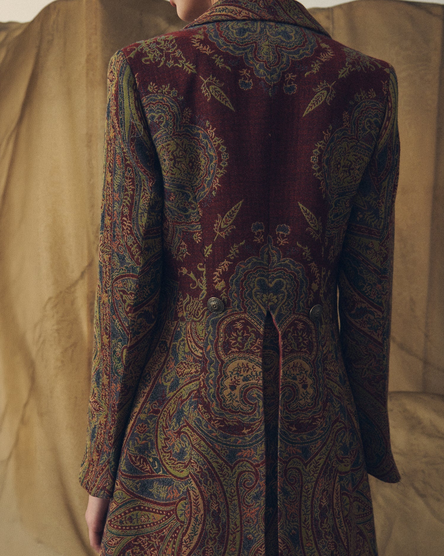 Close-up back view of women's Jacquard Lancelot coat showing paisley weave texture and decorative waist buttons by T.ba