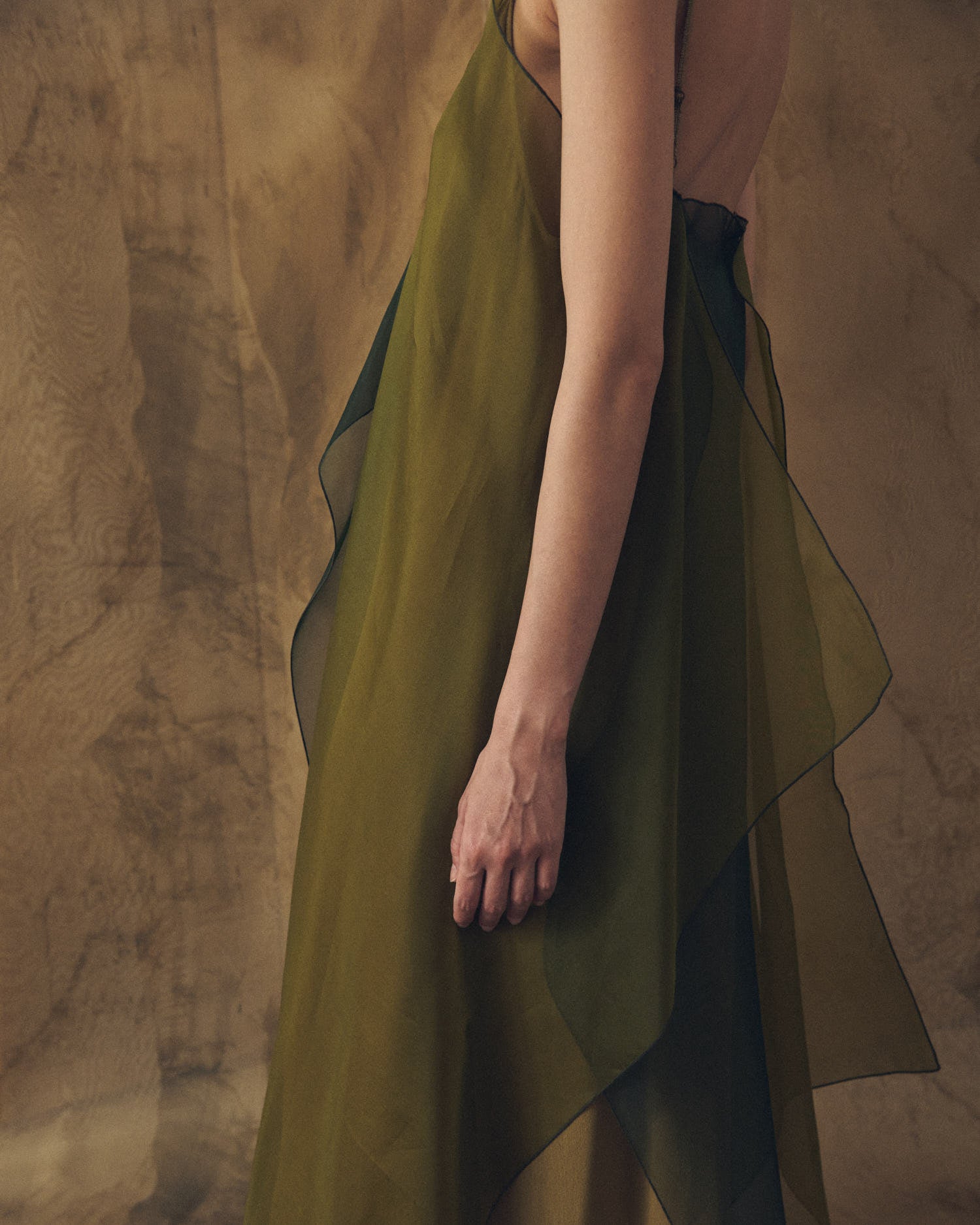 Close-up detail view of the sheer organza fabric and flowing layers of the Panarea dress in hunting green by T.ba