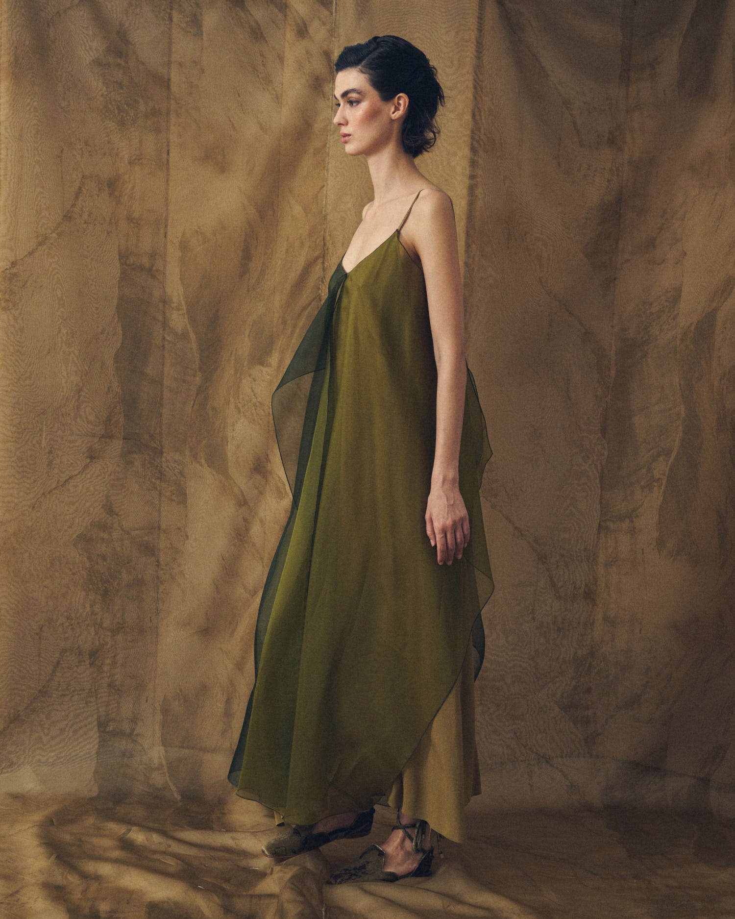 Side profile view of model wearing the Panarea fluid organza maxi dress in hunting green by T.ba