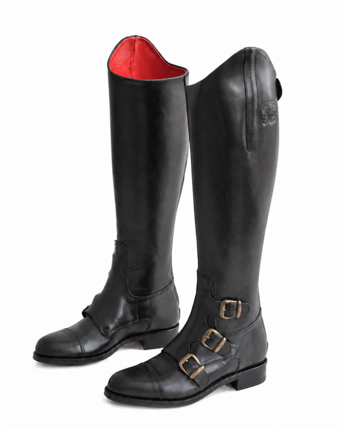Perspective shot of pair of women's black leather riding boots showing red interior lining and buckle details T.ba