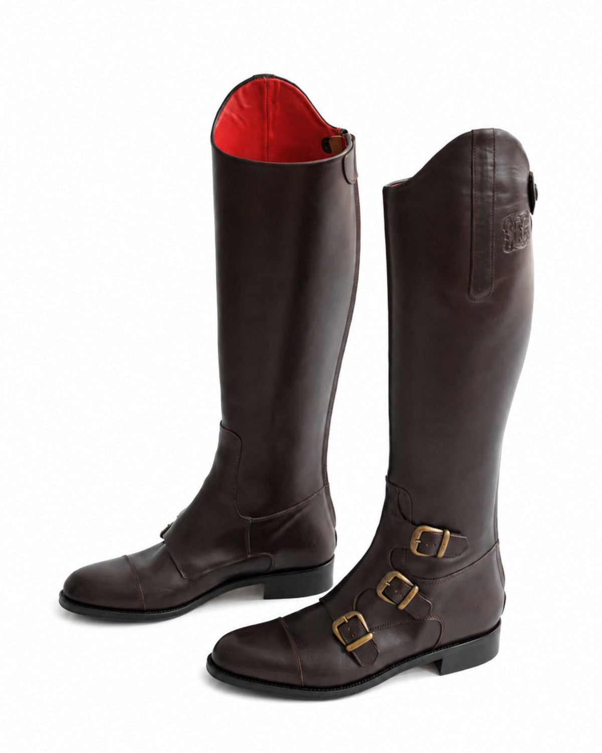 Perspective view of a pair of women's chocolate leather riding boots showing side buckles and red interior T.ba