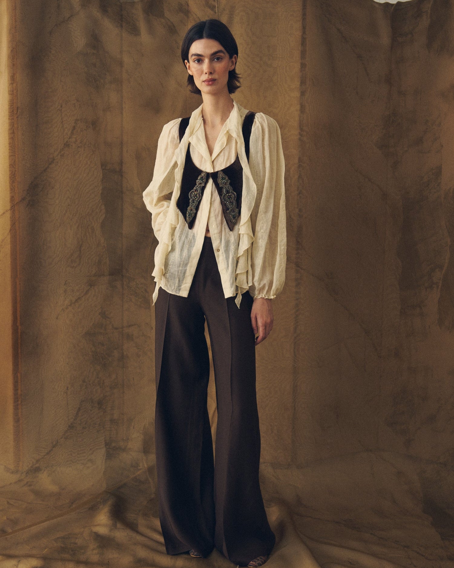 Full length shot of model styled in the loose Ramie Embroidered Pienza Blouse in natural combined with dark trousers for women by T.ba
