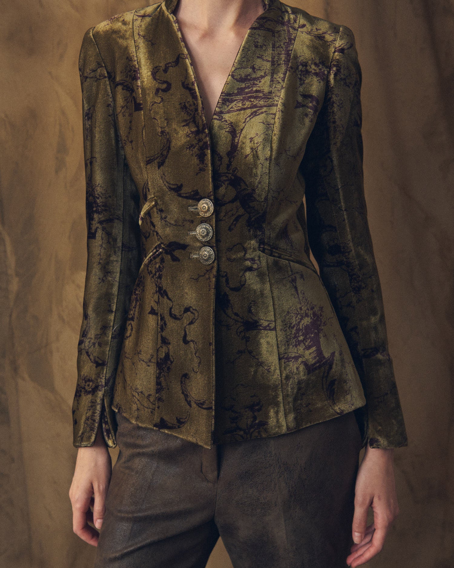 Medium portrait view of model wearing the fitted Sam printed silk velvet jacket in mocca green by T.ba