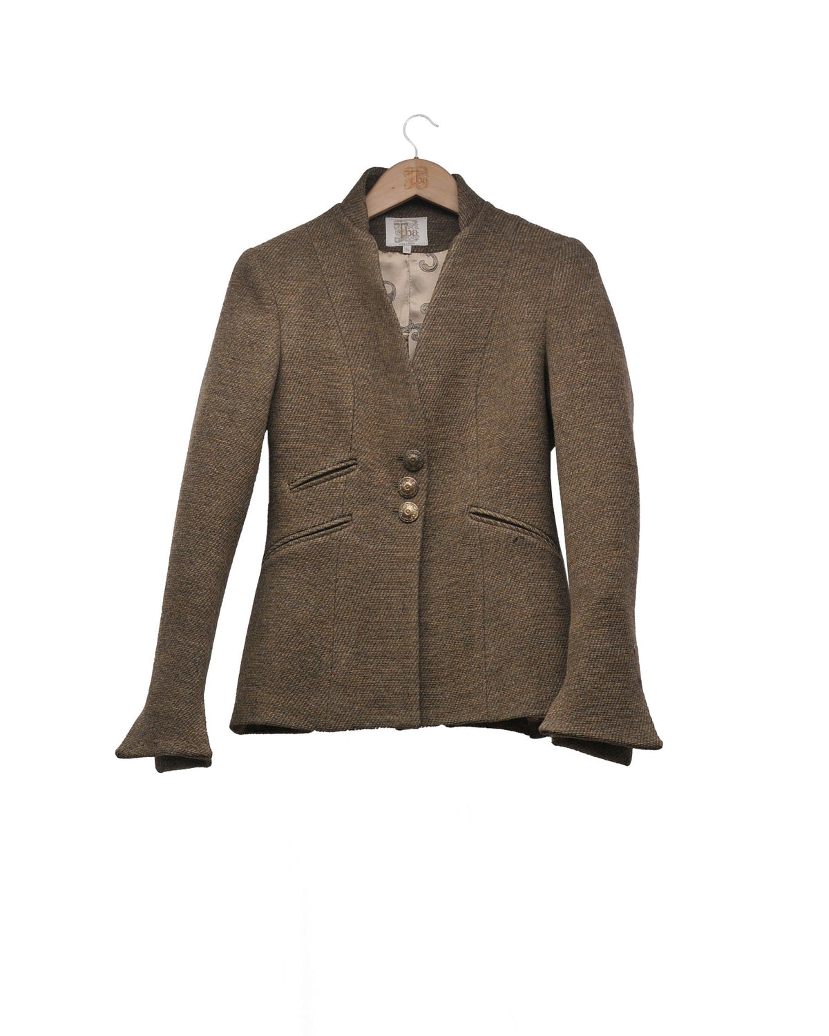 Front studio view on hanger of the tailored Sam jacket in brown wool tweed with standing collar and metal buttons by T.ba