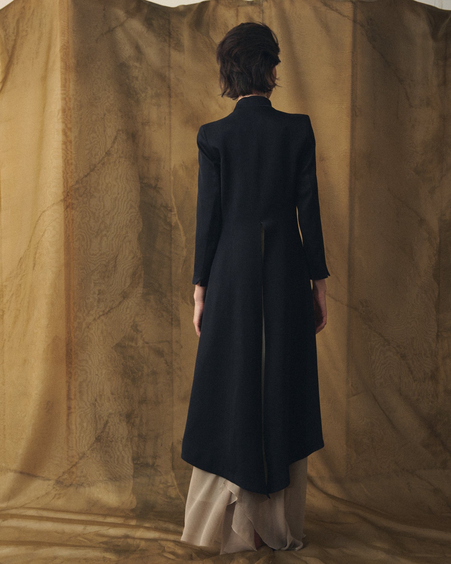 Back view of women's Black Sharkskin Ginebra long wool coat with back vent by T.ba