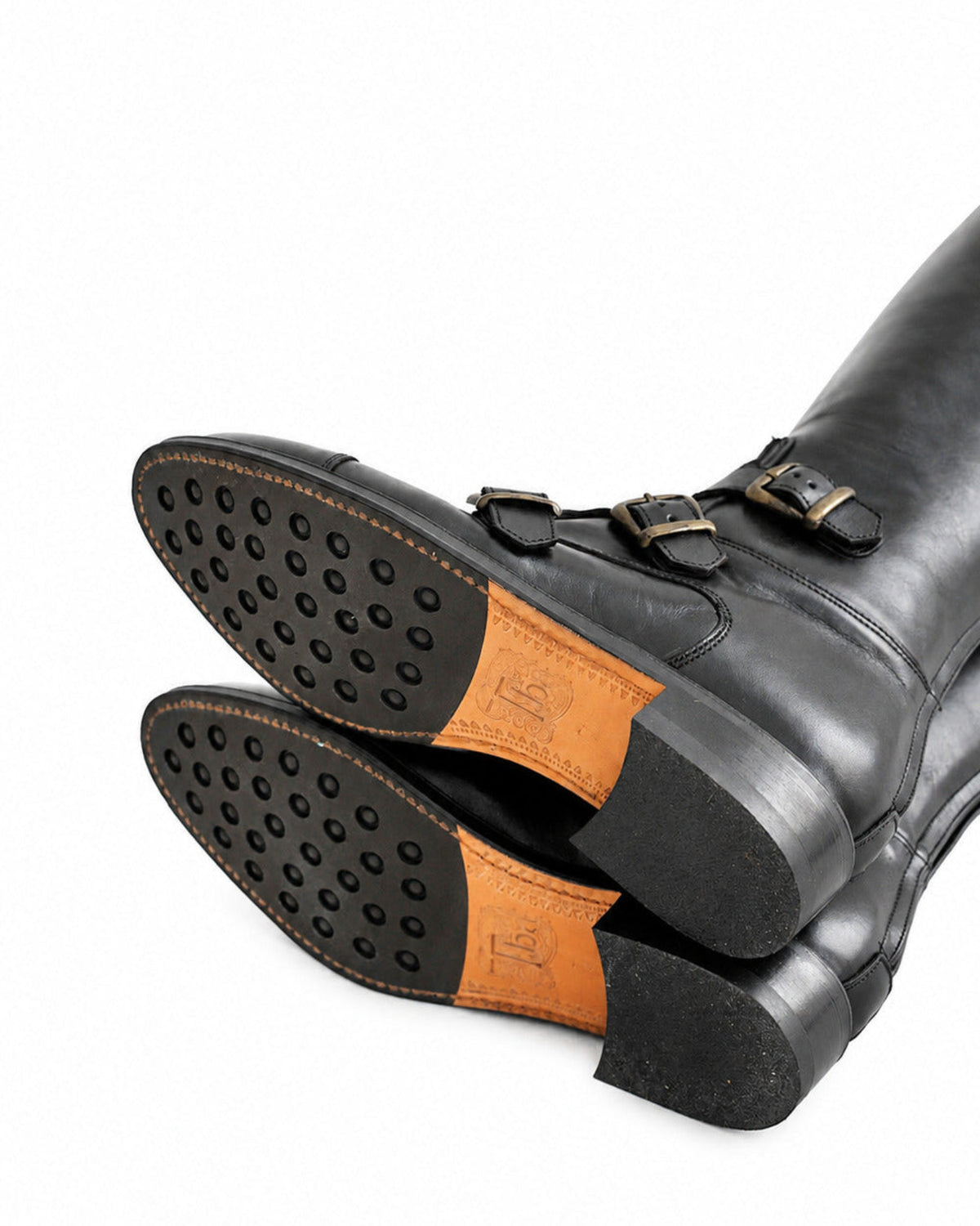 Bottom view highlighting rubber studded grip leather soles and embossed logo of black riding boots T.ba