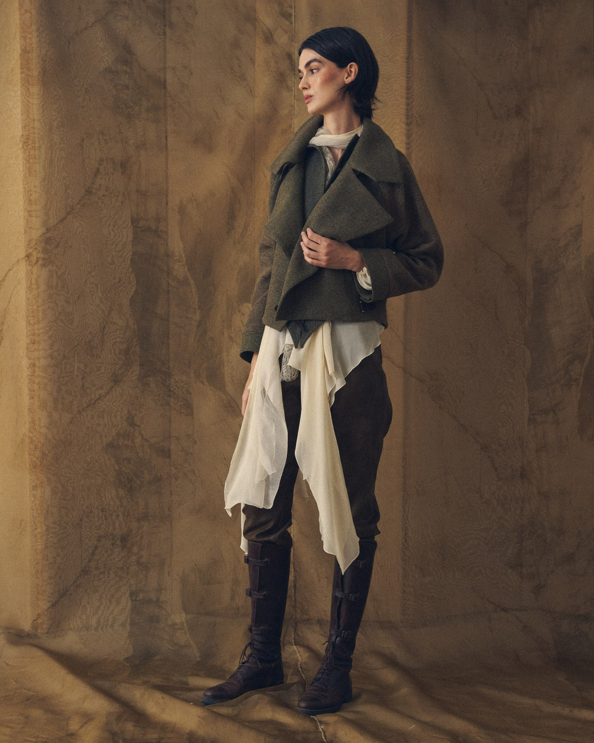 Full look of model wearing dark brown leather straps high riding boots with laces and buckles T.ba