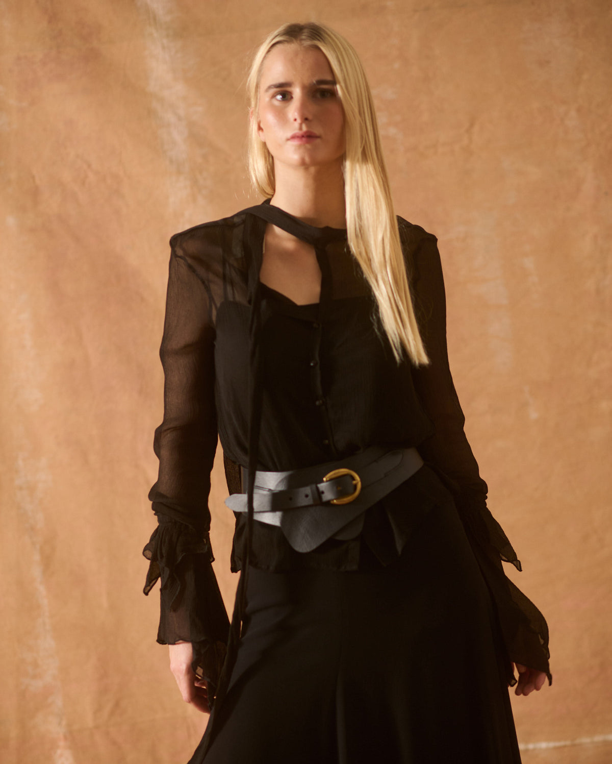 Half-body front view of model showcasing the wide black leather Toscana Belt featuring a gold metallic buckle for women by T.ba