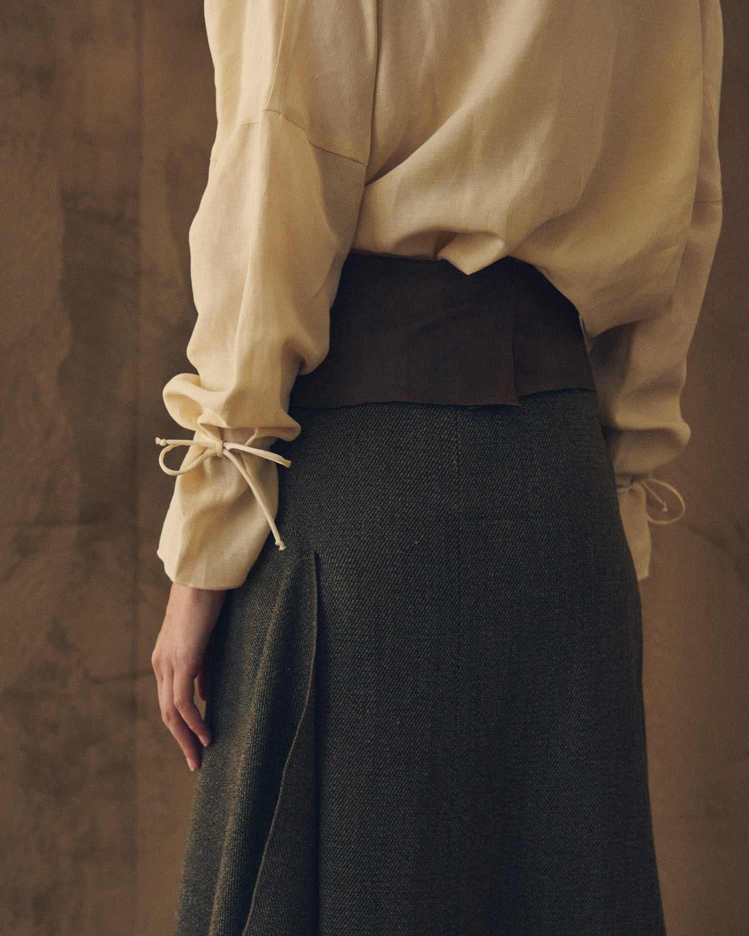 Close-up detail shot showing the green tweed texture and tailored drape of the Toscana skirt by T.ba
