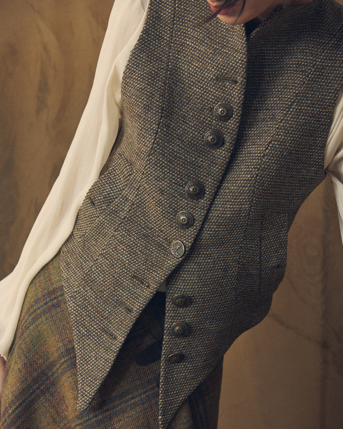 Close-up front detail of the Tweed Knit Baltea Vest highlighting the textured tweed weave and vintage metallic buttons by T.ba.