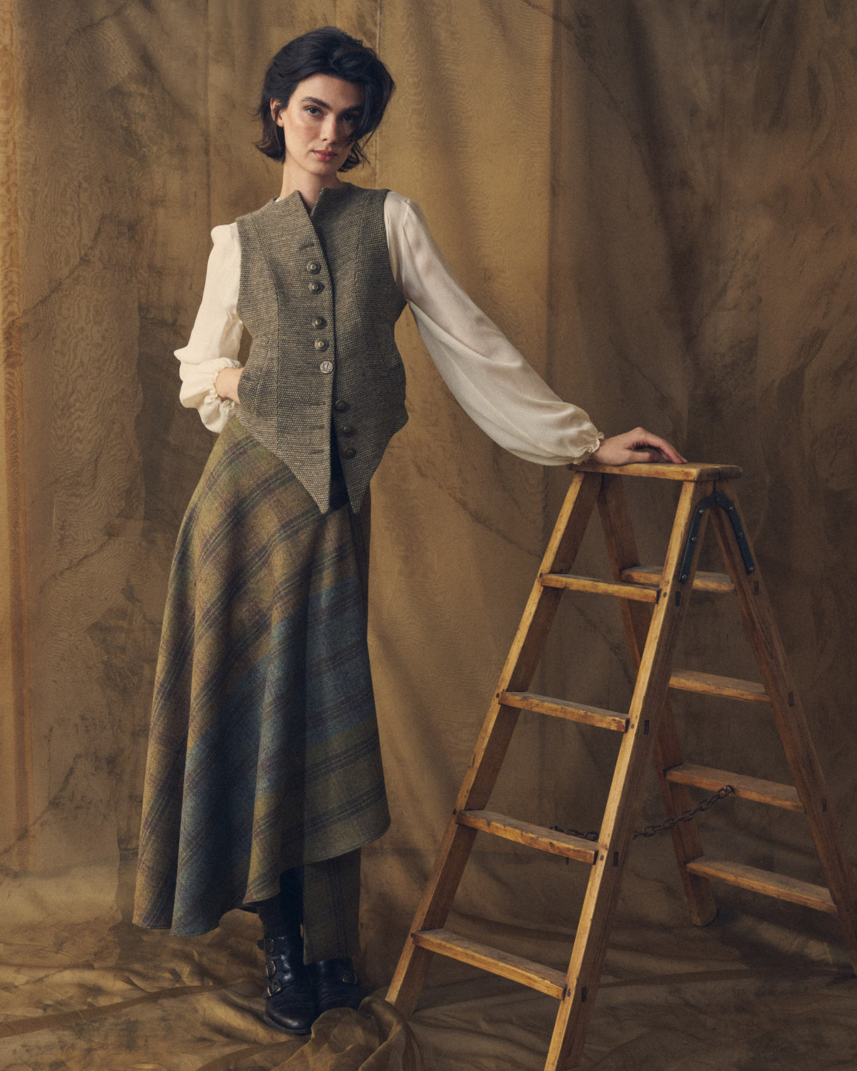Full-length view of the Tweed Knit Baltea Vest in taupe brown wool paired with a flared plaid skirt for women by T.ba.