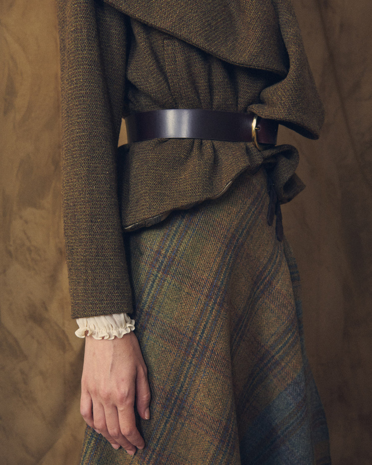 Close-up shot showing the plaid wool texture and waistband detail of the Tweed Lancelot Skirt Mix for women by T.ba
