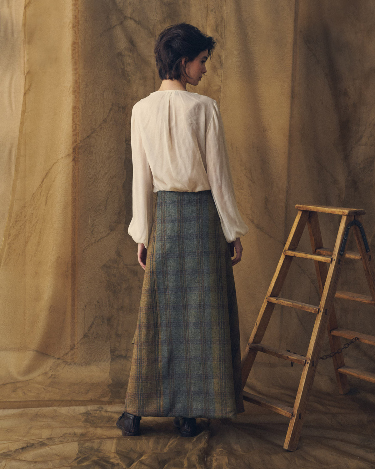 Back view of model wearing the Tweed Lancelot Skirt Mix in plaid wool featuring a clean straight back fit for women by T.ba