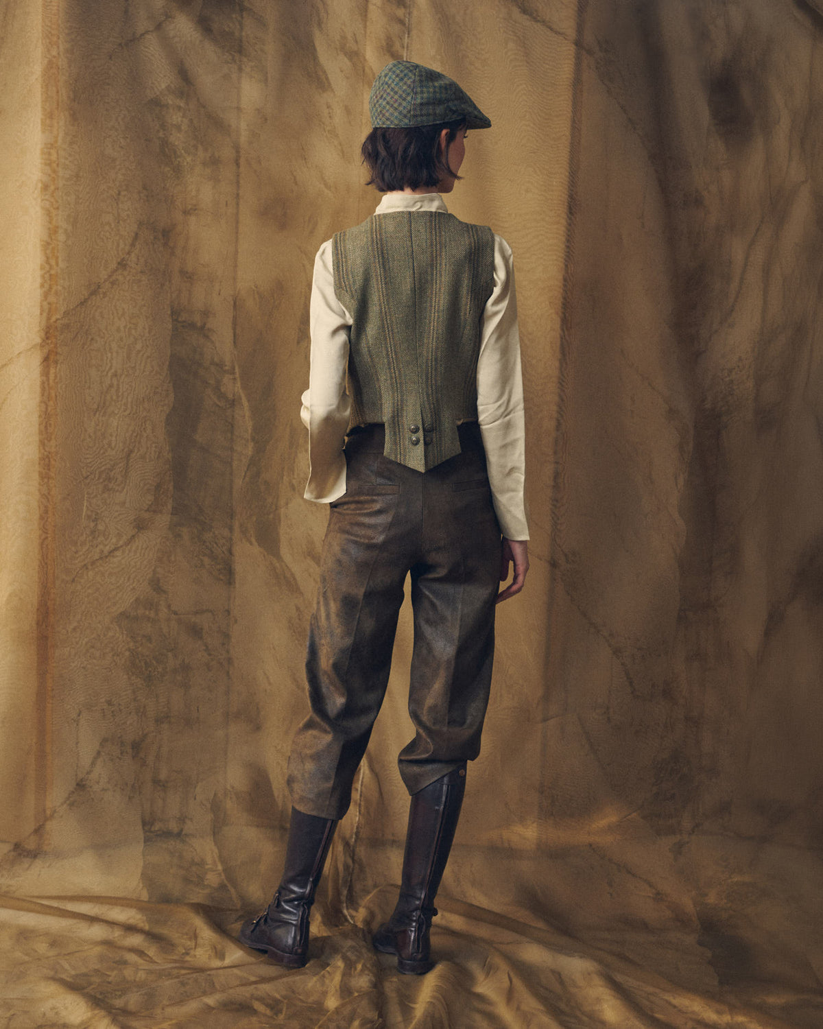 Full-length back view of a model wearing the Tweed Short Baltea Vest highlighting the tailored back waist line for women by T.ba.