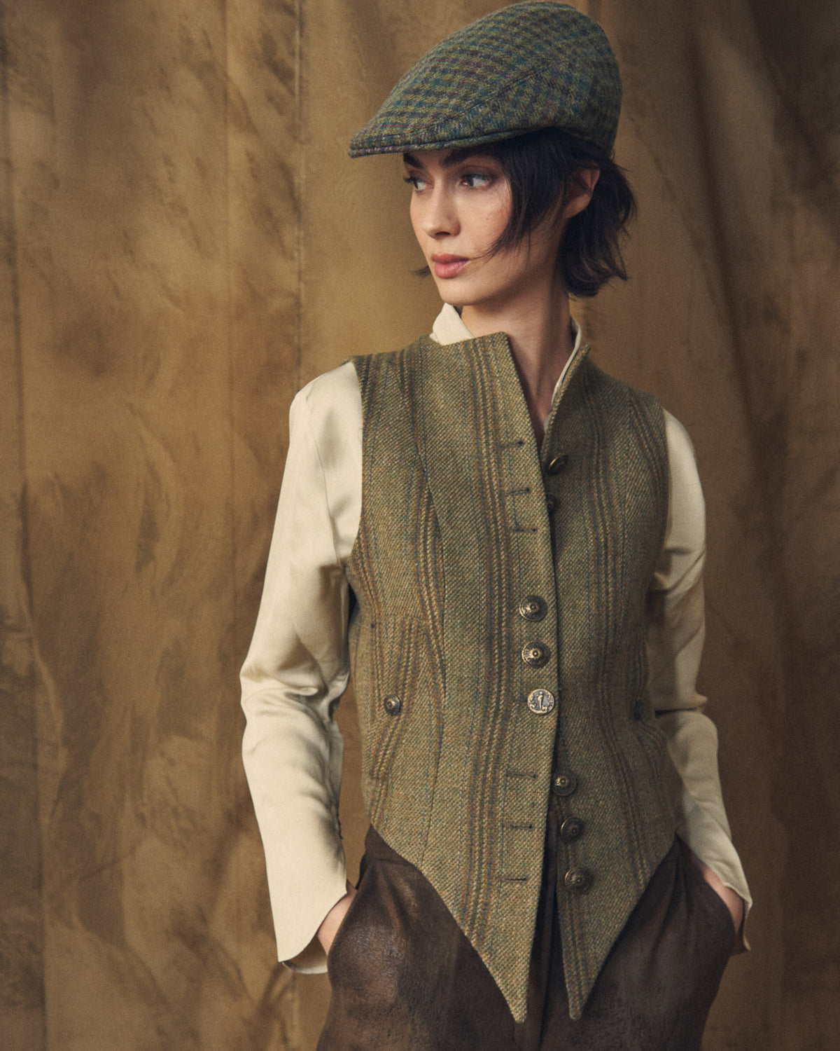 Medium shot of a model wearing the Tweed Short Baltea Vest showing the structured front hem and metallic buttons by T.ba.