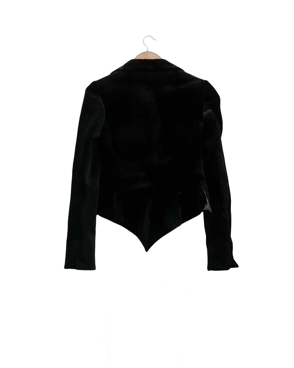 Back studio view on hanger of the fitted black Verdi silk velvet short jacket showing V-shaped cut hem by T.ba