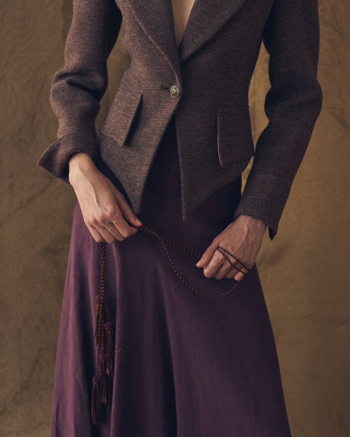 Medium close-up of the fitted Verdi Tweed Knit jacket in grape showing asymmetrical hem and flap pockets by T.ba